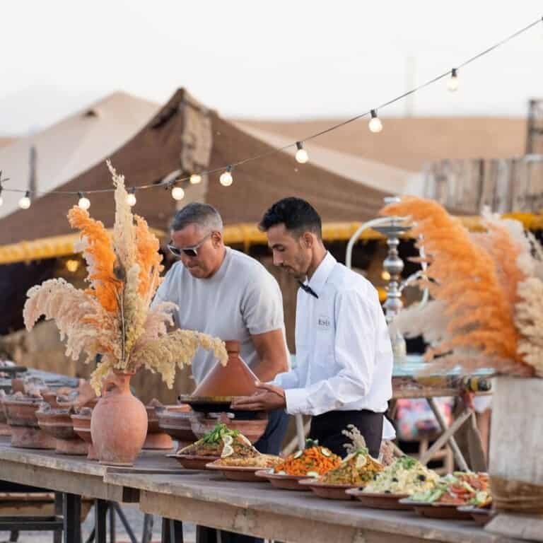Two men preparing a Desert dinner buffet in Agafay Desert