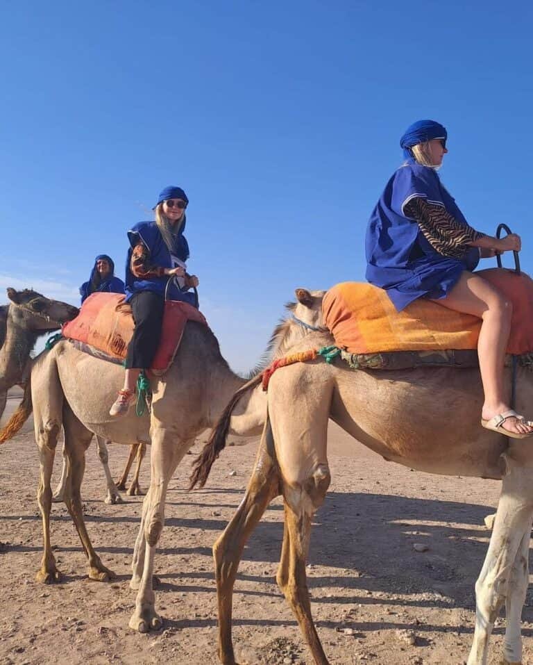 Two ladies riding camels at agafay Desert