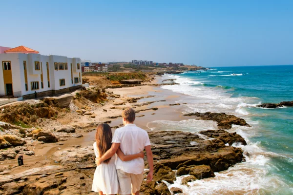 A couple gazing toward Asilah beach in Morocco