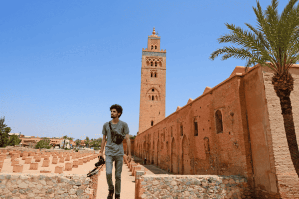 A man with a camera walking by the Koutoubia Mosque in Marrakech