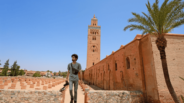 A man with a camera walking by the Koutoubia Mosque in Marrakech