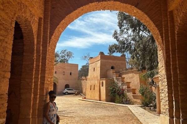 A person standing at an arch of the Medina coco Polizzi, in Agadir