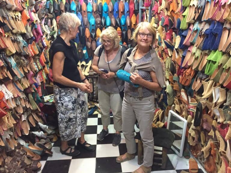 Three Tourist ladies in Fes, Morocco tour, checking leather shop goods