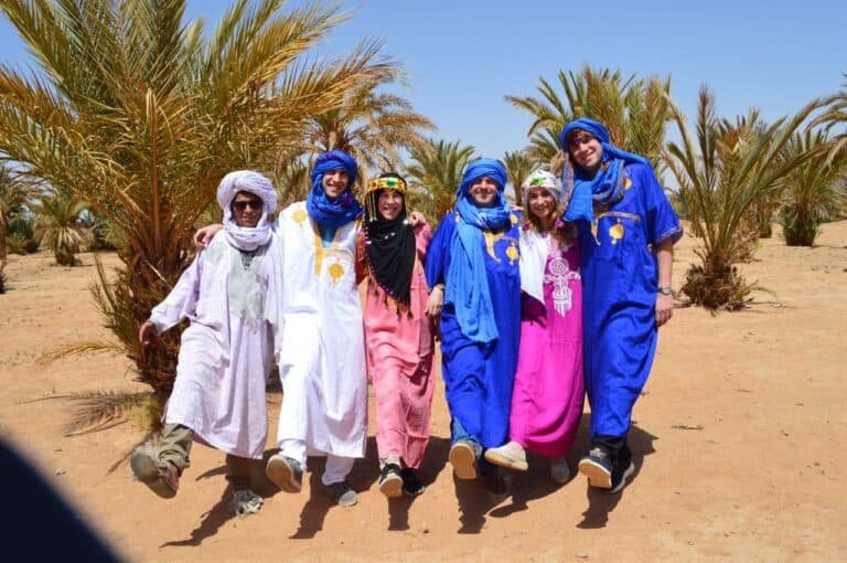 Tourists and local guide posing at marrakech palm groove, Morocco