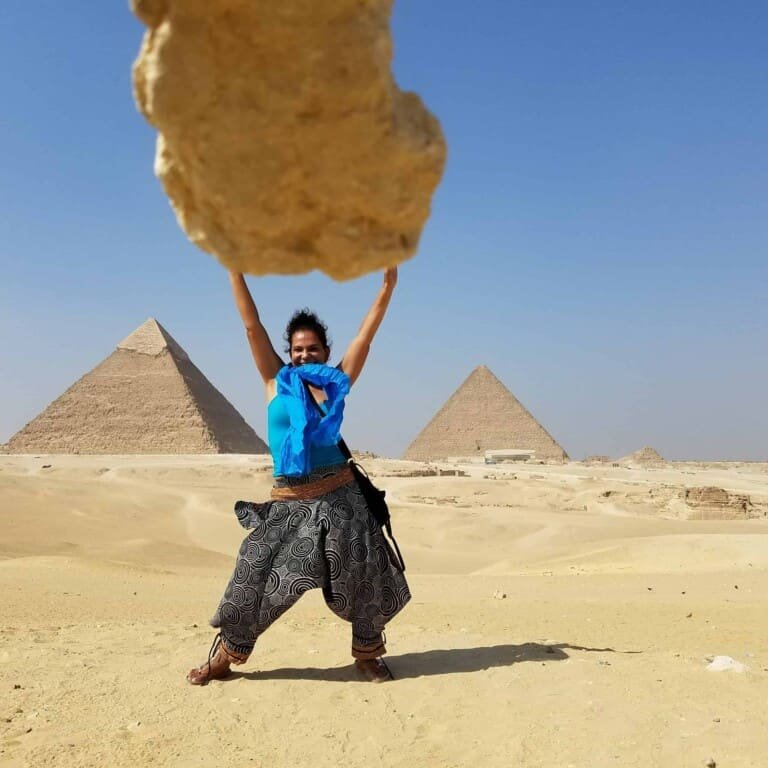 A person posinng at Pyramids of Giza in Cairo