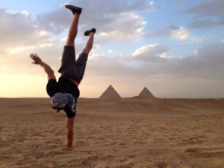 Amazing photo of a tourist standing in one hand at The Pyramids of Giza