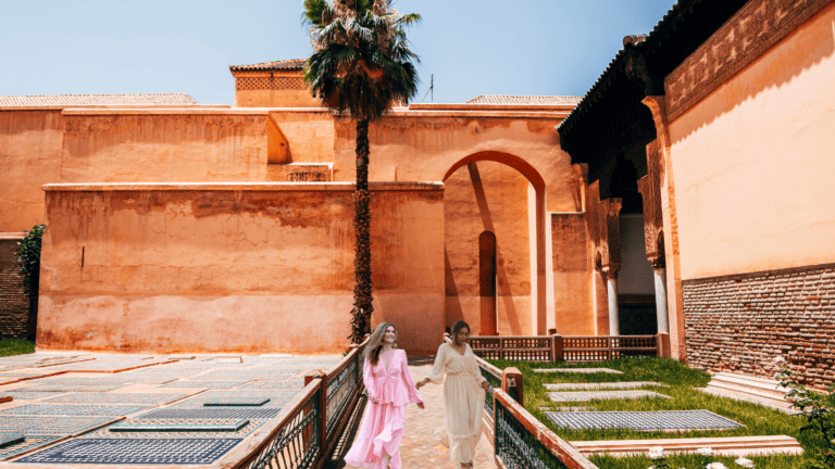 Two ladies walking by the saadian tombs monument in Marrakech