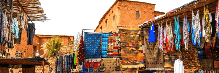 Ait Beh Haddou location with colorful carpets and local clothing