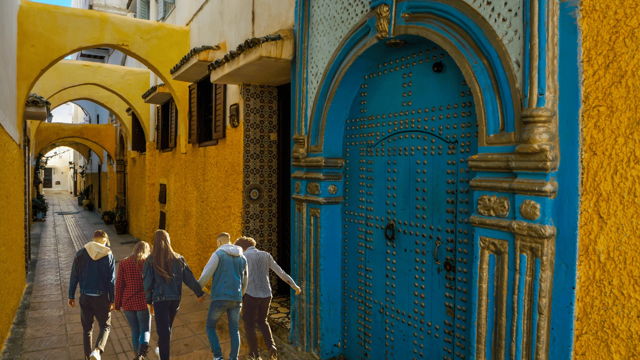 Five people walking in a Rabat Medina's street