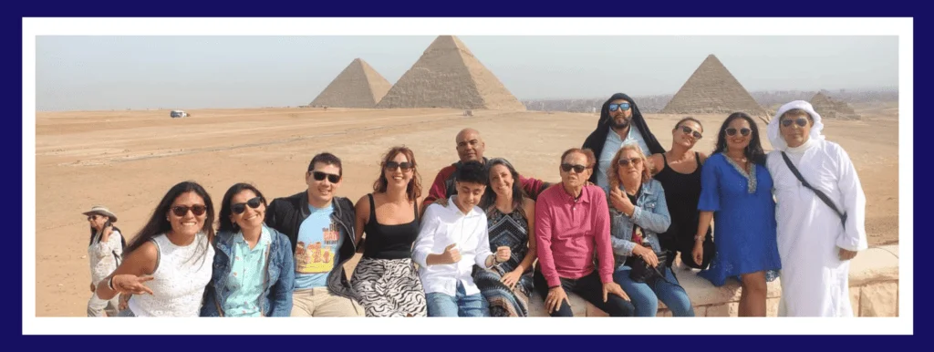 Egyptian tour guide with a group of tourist in front of Pyramids of Giza