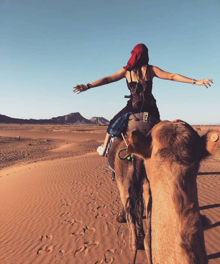 A woman riding a camel at Zagora Desert Camp